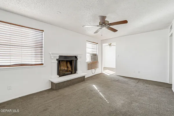 an empty room with a window and a ceiling fan