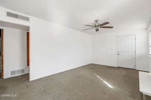 a view of an empty room with a fireplace and a window