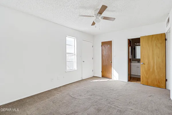 a view of an empty room with closet and a chandelier fan