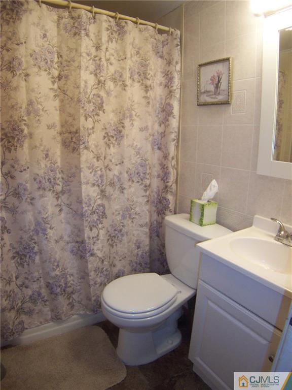 14 West Cliff Road Colonia, NJ 07067 - Photo 11 of 18 a white toilet sitting next to a shower curtain