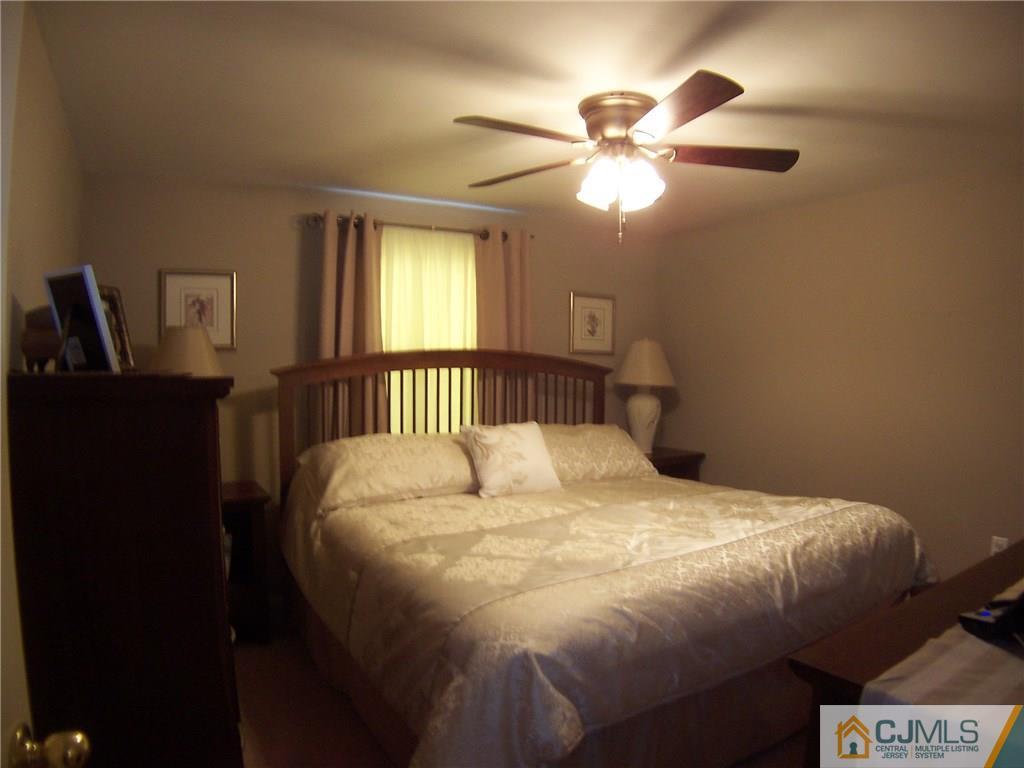 14 West Cliff Road Colonia, NJ 07067 - Photo 12 of 18 a large bed sitting in a bedroom next to a window