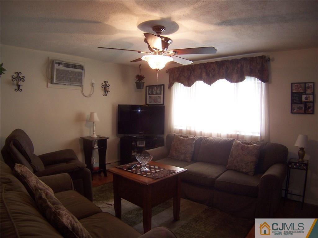 14 West Cliff Road Colonia, NJ 07067 - Photo 10 of 18 a living room with furniture a chandelier and a window