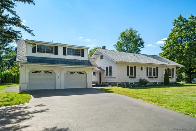 a view of a yard in front of a house with large tree