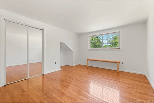 a view of empty room with wooden floor
