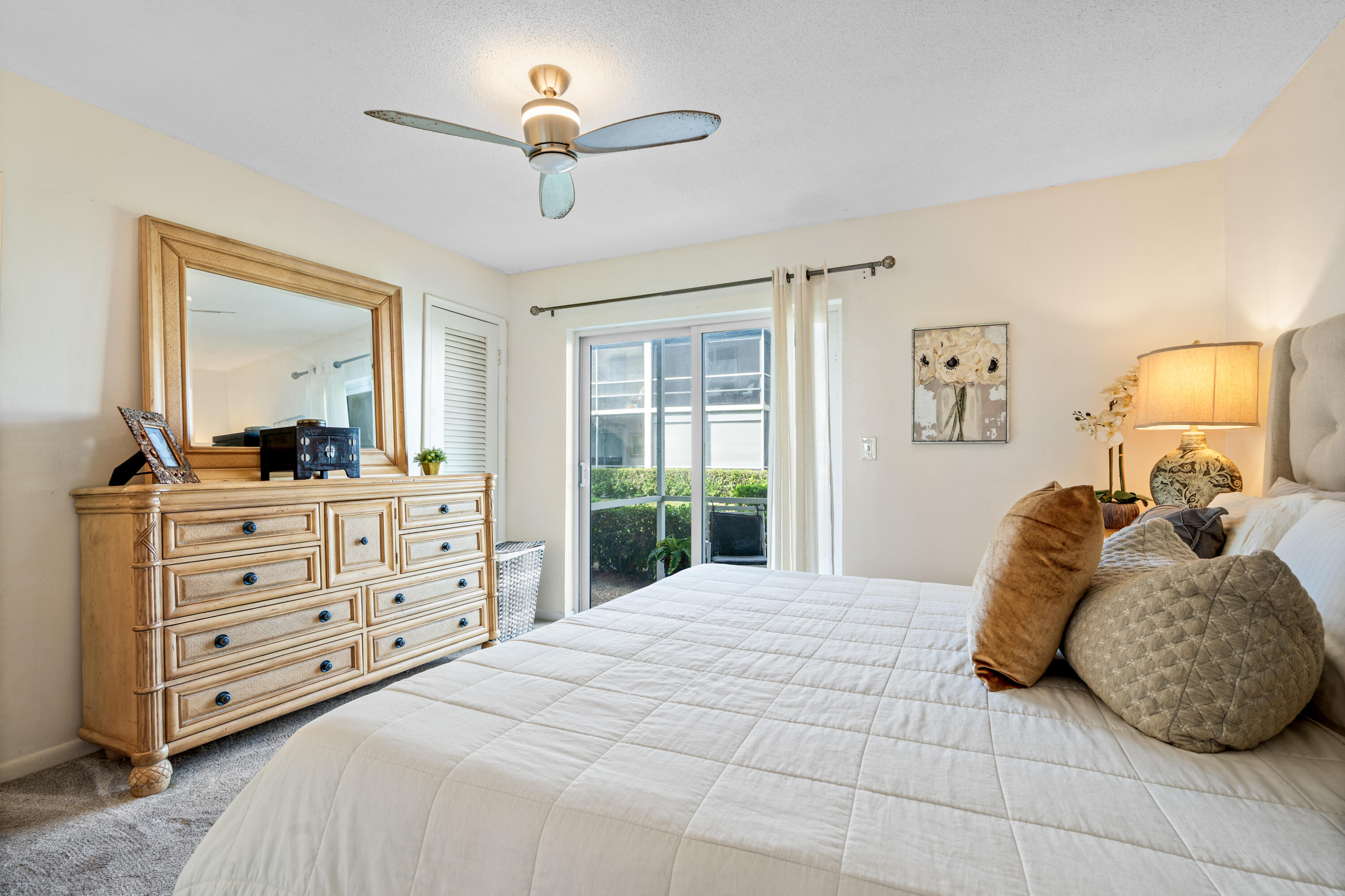 320 Horizon West, Unit 103 Boynton Beach, FL 33435 - Photo 2 of 24 a bedroom with a large bed and a dresser