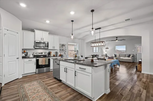 a kitchen with stainless steel appliances granite countertop a stove and cabinets