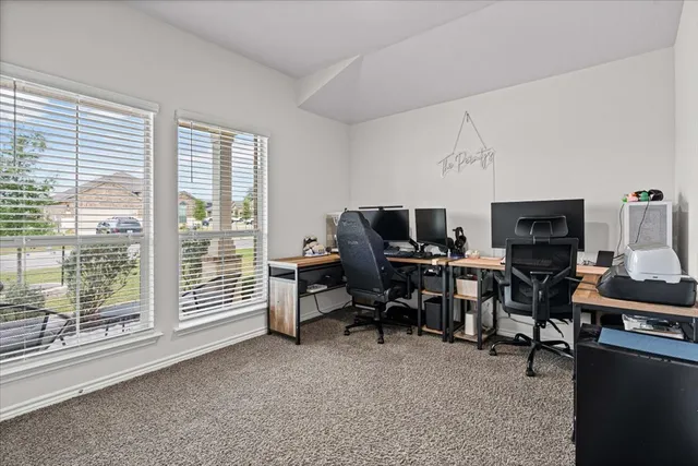 a view of a workspace with furniture and a window