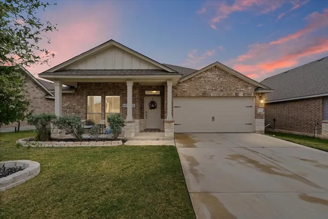 a front view of a house with a yard garage and outdoor seating