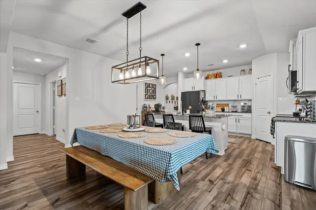 a open kitchen with stainless steel appliances granite countertop a stove a refrigerator a kitchen island a sink and a wooden floors