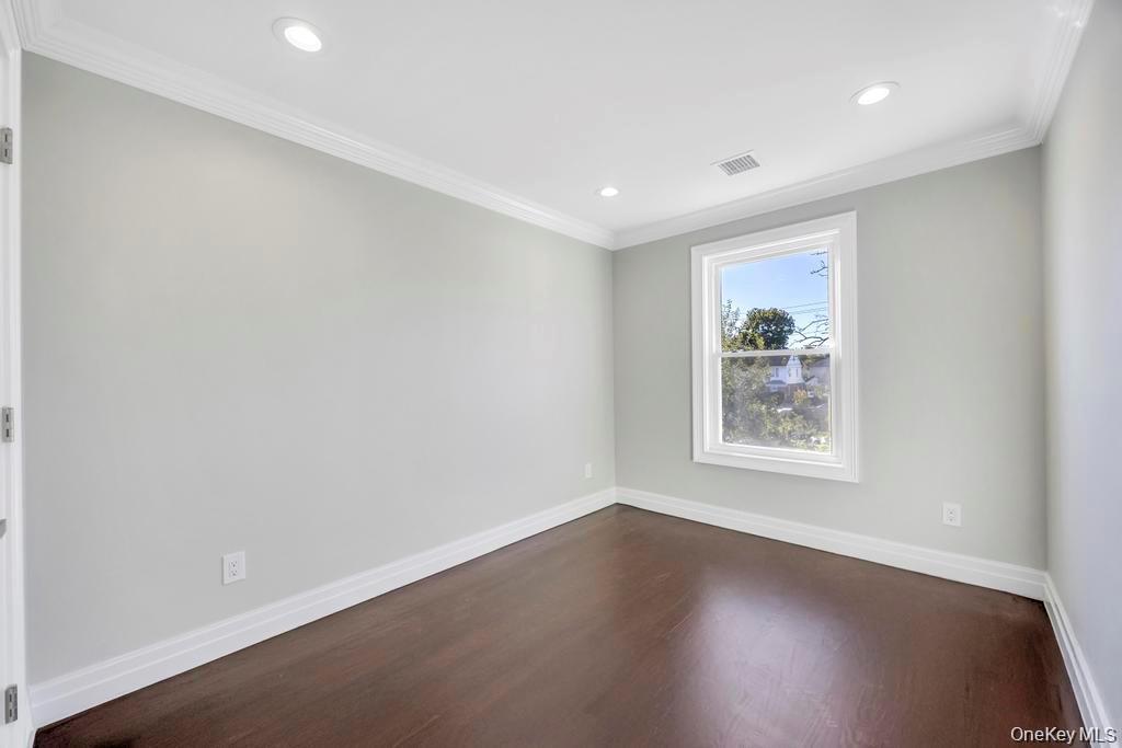 41 Perry Street Hempstead, NY 11550 - Photo 16 of 36 Spare room featuring dark wood-type flooring, crown molding, and recessed lighting