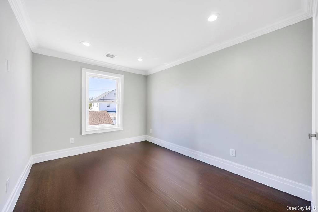 41 Perry Street Hempstead, NY 11550 - Photo 23 of 36 Spare room featuring crown molding, dark wood-style floors, and recessed lighting