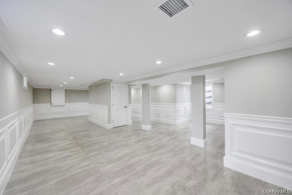 41 Perry Street Hempstead, NY 11550 - Photo 25 of 36 Basement with a decorative wall, wainscoting, recessed lighting, and ornamental molding