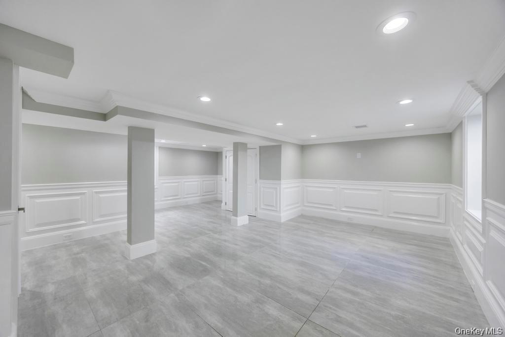 41 Perry Street Hempstead, NY 11550 - Photo 27 of 36 Finished basement with wainscoting, a decorative wall, recessed lighting, and ornamental molding