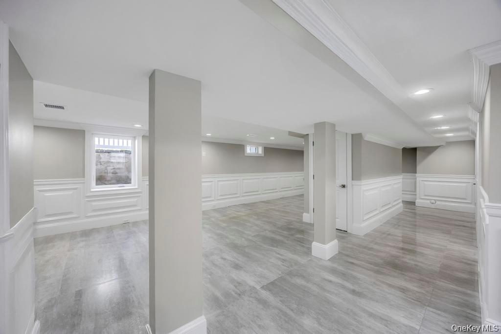 41 Perry Street Hempstead, NY 11550 - Photo 32 of 36 Basement with a decorative wall, a wainscoted wall, healthy amount of natural light, and light wood-style floors