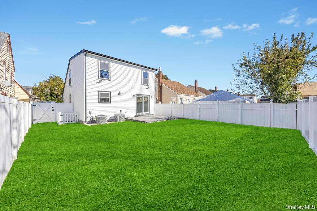 41 Perry Street Hempstead, NY 11550 - Photo 35 of 36 Back of house with a gate, a fenced backyard, and a patio