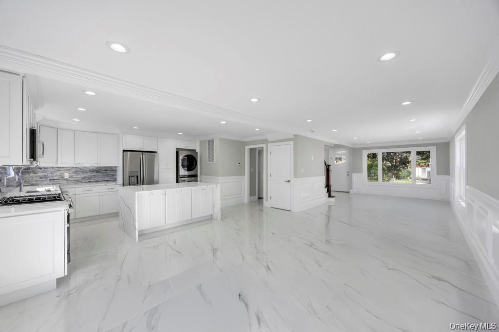 41 Perry Street Hempstead, NY 11550 - Photo 5 of 36 Unfurnished living room with a decorative wall, wainscoting, light marble finish floors, crown molding, and recessed lighting