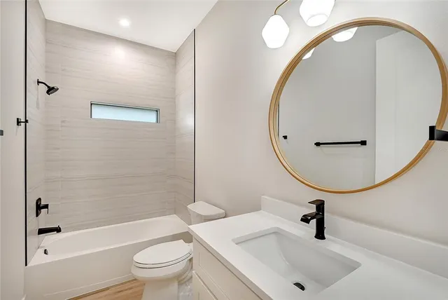 a bathroom with a sink a toilet and a mirror