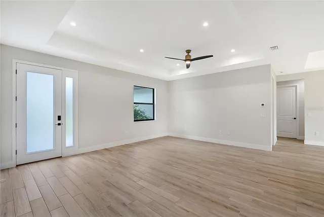 an empty room with wooden floor and windows