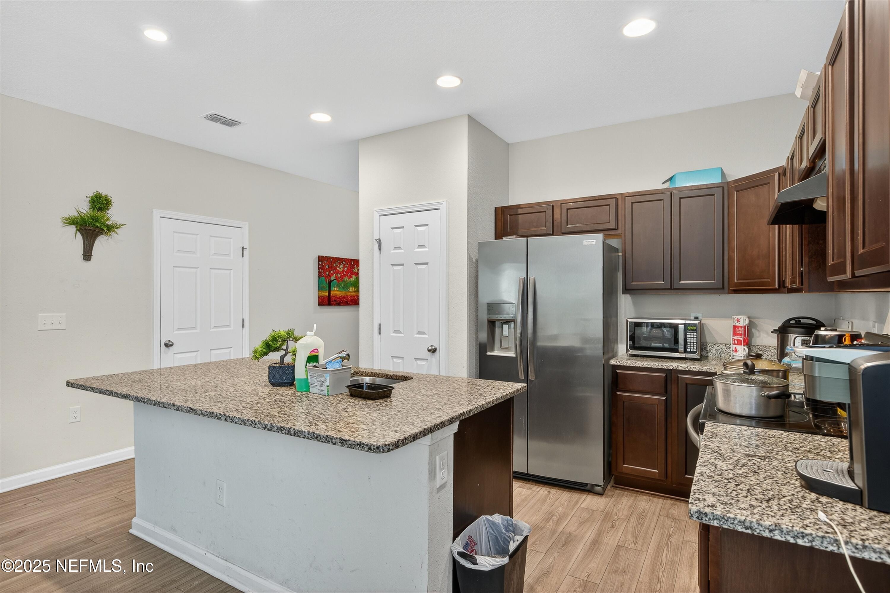 756 Talking Tree Drive Jacksonville, FL 32205 - Photo 13 of 26 a kitchen with stainless steel appliances granite countertop a kitchen island a stove a refrigerator a sink a dining table and chairs