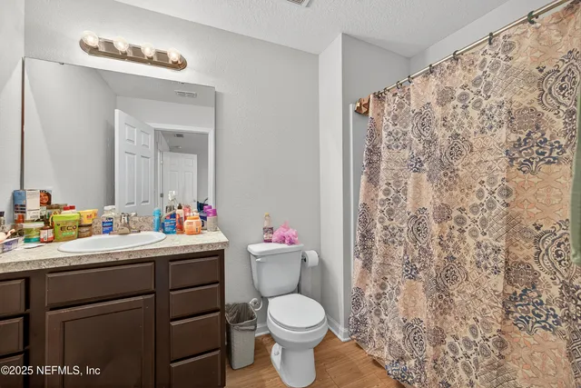 a bathroom with a toilet sink vanity and mirror