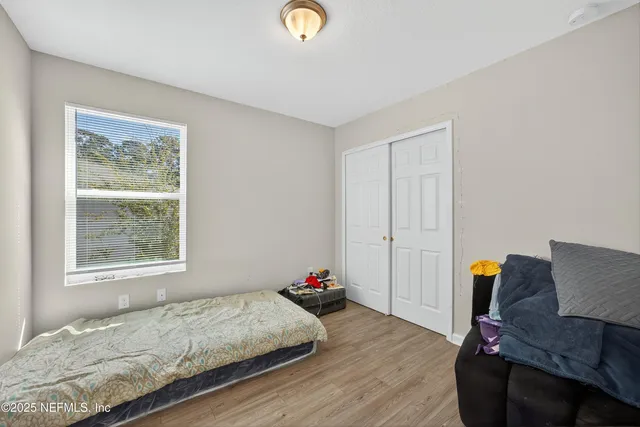 a bedroom with a bed and wooden floor