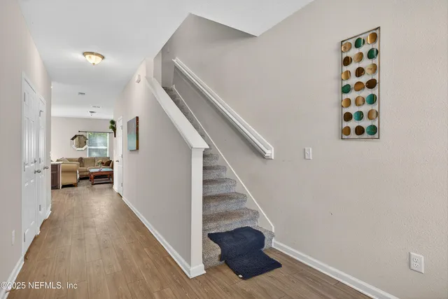 a view of entryway and hall with wooden floor