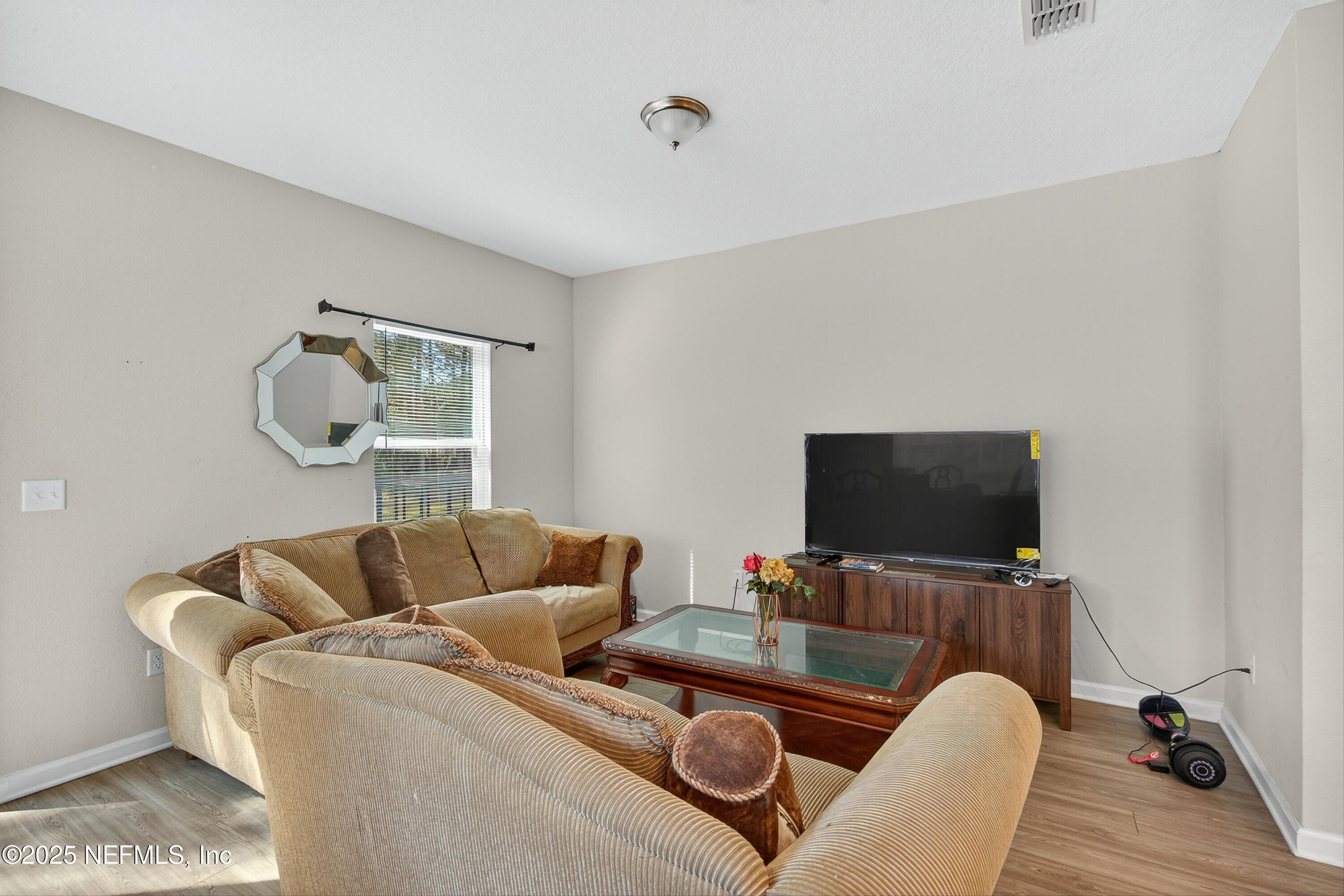 756 Talking Tree Drive Jacksonville, FL 32205 - Photo 9 of 26 a living room with furniture and a flat screen tv
