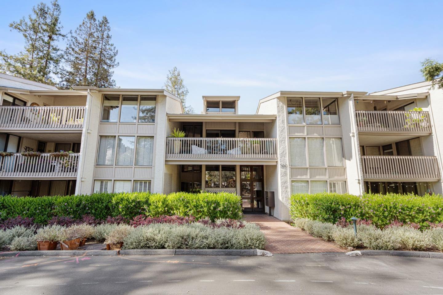 300 Sand Hill Circle, Unit 303 Menlo Park, CA 94025 - Photo 33 of 33 a front view of multi story residential apartment building with yard and bench