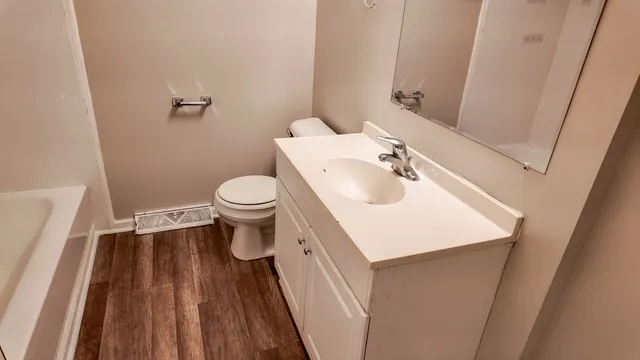 a bathroom with a sink a toilet and a mirror