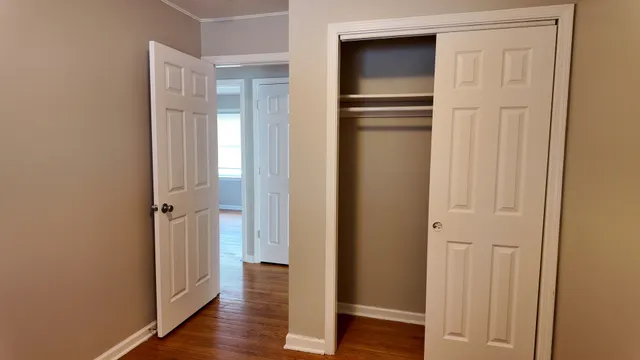 a view of empty room with wooden floor