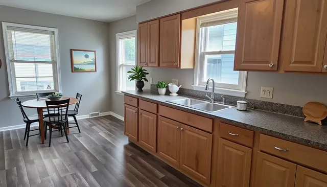 a kitchen with stainless steel appliances granite countertop wooden floors and wooden cabinets