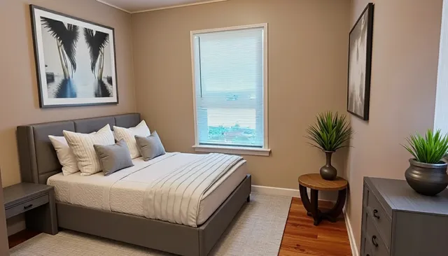 a bedroom with a bed and a potted plant