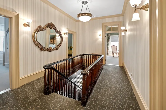 a view of a hallway with wooden floor and windows