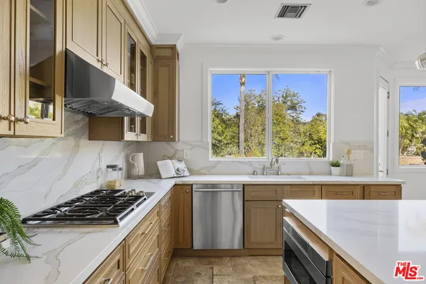 a kitchen with a stove a sink and a window