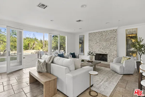 a living room with fireplace furniture and a large window