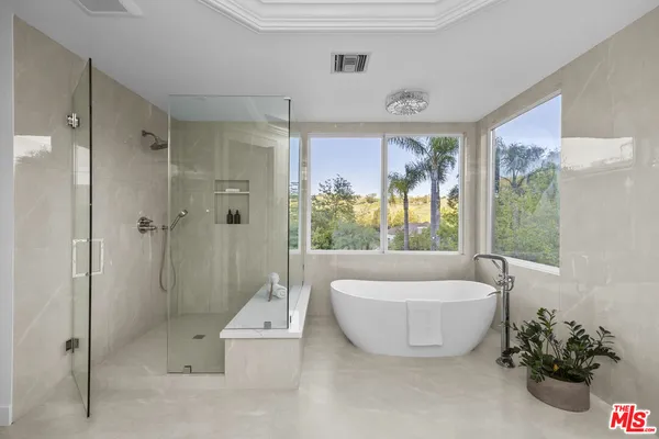 a bathroom with a tub a window and a shower