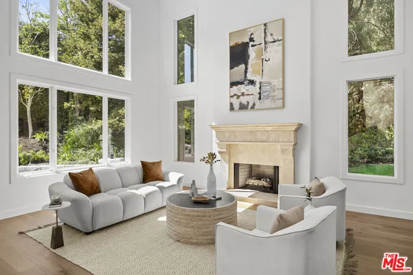 a living room with furniture a fireplace and a large window
