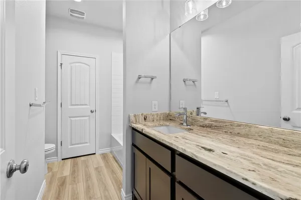 a bathroom with a granite countertop sink and a mirror
