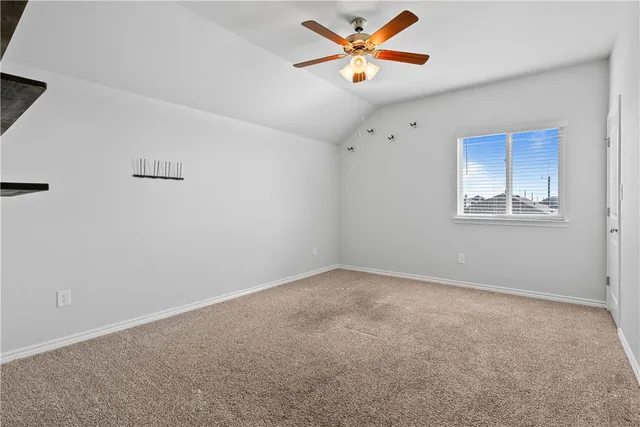 an empty room with window and ceiling fan