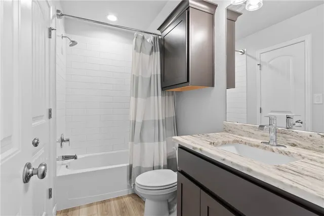 a bathroom with a granite countertop sink toilet and shower