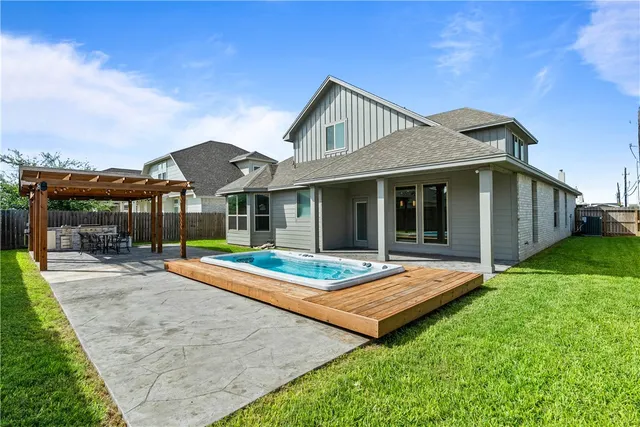 a view of a house with table and chairs next to a yard