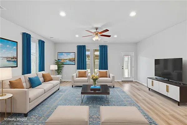 a living room with furniture flat screen tv and large couches