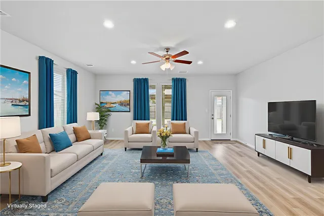 a living room with furniture flat screen tv and large couches