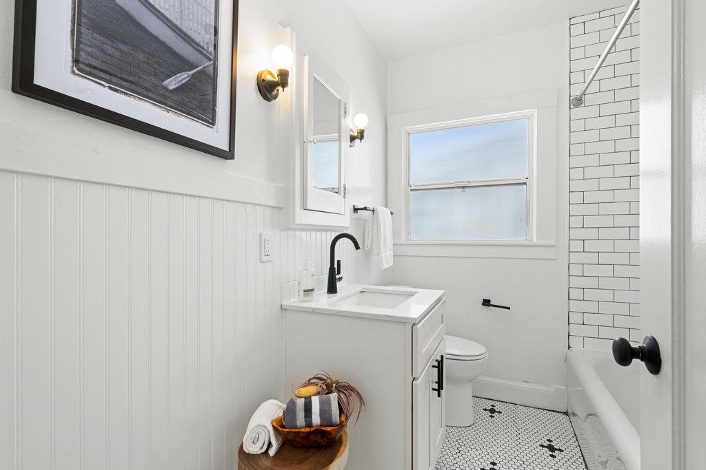 1220 Peralta Avenue Berkeley, CA 94706 - Photo 11 of 15 a bathroom with a sink mirror and toilet