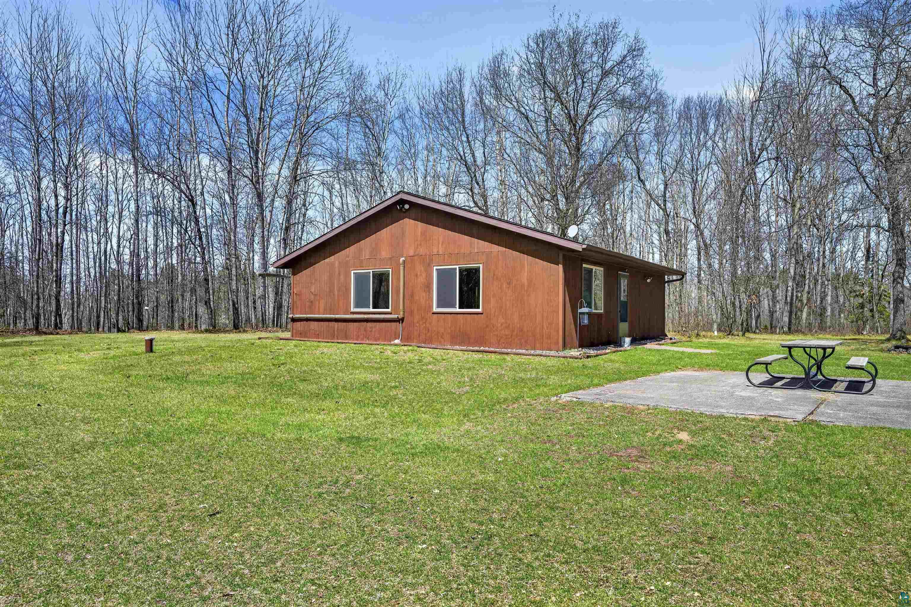 12235 East Crooked Lake Road Gordon, WI 54838 - Photo 31 of 48 Brown-sided structure set on a large grassy expanse, bordered by mature trees