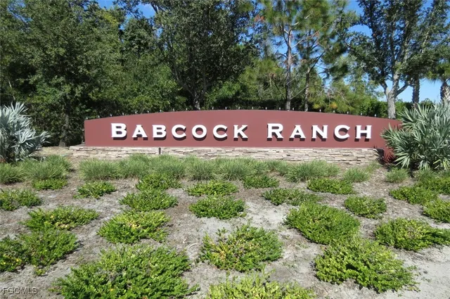 a sign that is sitting in front of a tree