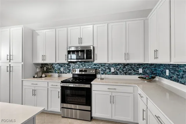 a kitchen with white cabinets and white appliances