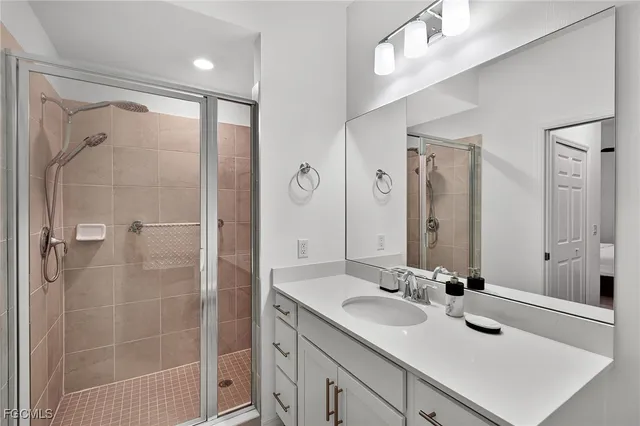 a bathroom with a shower sink vanity and mirror