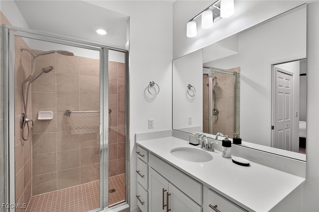 43997 Boardwalk Loop, Unit 1841 Punta Gorda, FL 33982 - Photo 26 of 43 a bathroom with a shower sink vanity and mirror