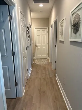 a view of a hallway with wooden floor and staircase